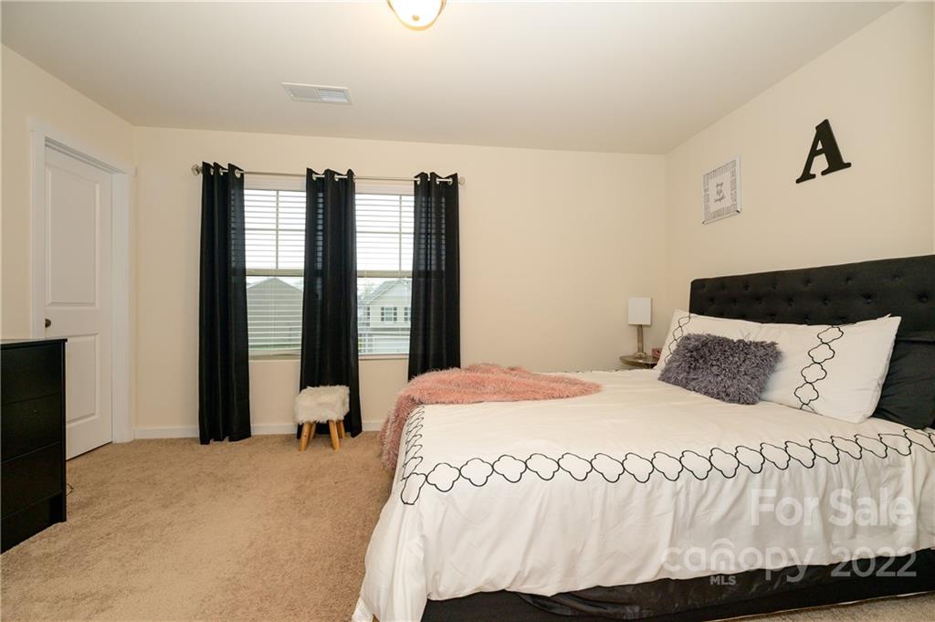 4626 Gibbons Link Road Charlotte, NC 28269 - Photo 17 of 20 a bedroom with a large bed and a large window