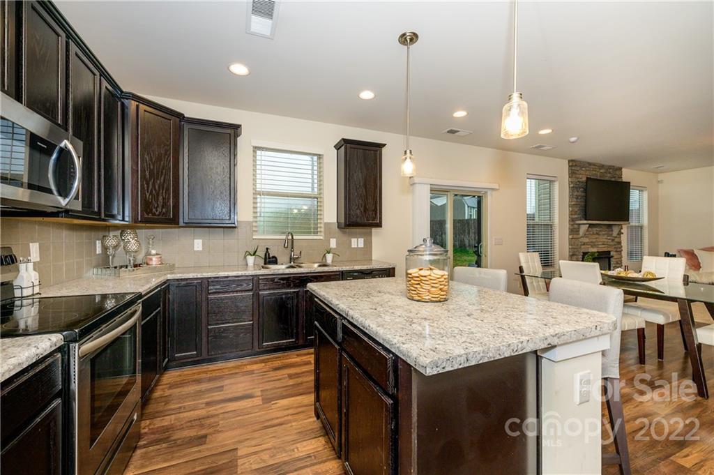4626 Gibbons Link Road Charlotte, NC 28269 - Photo 6 of 20 a kitchen with granite countertop kitchen island stainless steel appliances a sink stove top oven and cabinets