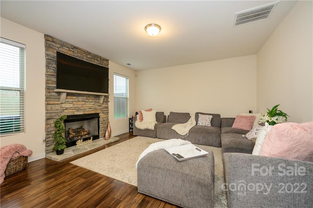 4626 Gibbons Link Road Charlotte, NC 28269 - Photo 9 of 20 a living room with furniture a fireplace and a flat screen tv