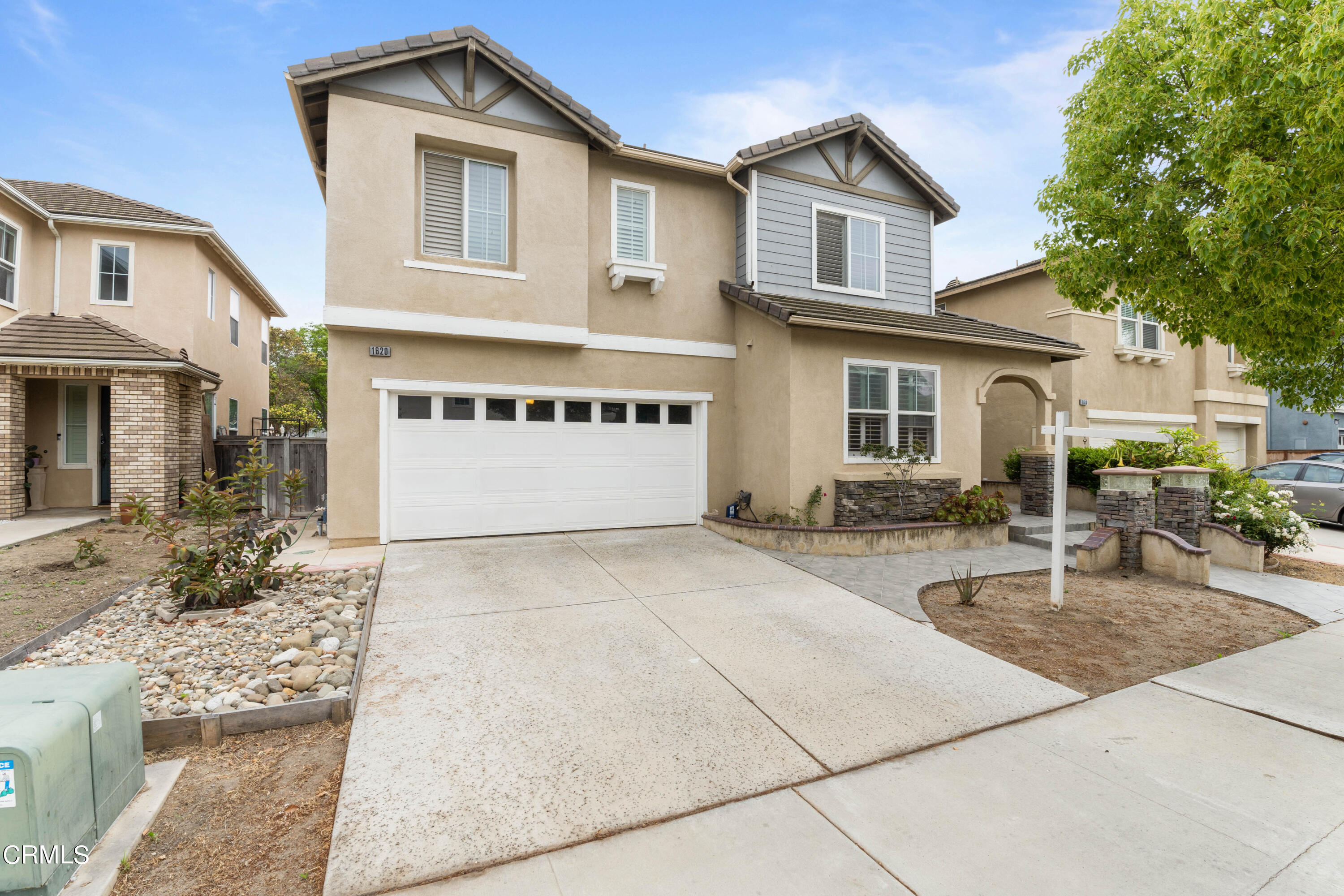 a front view of a house with yard and parking