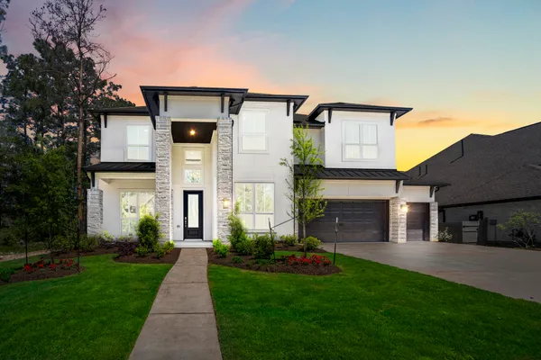 a front view of a house with a garden and plants