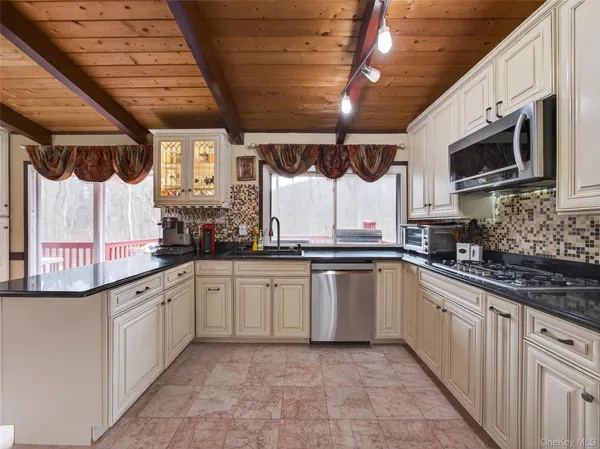 a kitchen with stainless steel appliances granite countertop a sink a microwave and cabinets