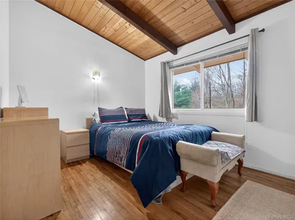 a spacious bedroom with a bed and wooden floor