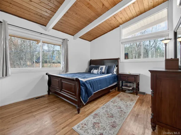 a bedroom with a bed and large windows