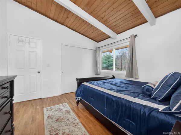 a bed sitting in a spacious bedroom next to a window