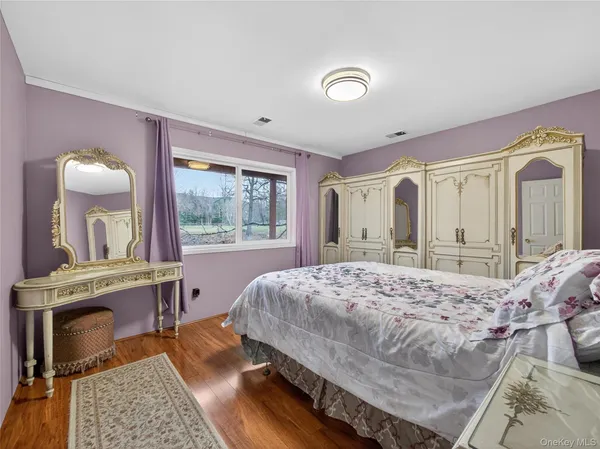 a bed sitting in a spacious bedroom next to a window