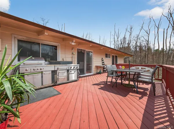 a view of a patio with table and chairs a barbeque with wooden floor and fence