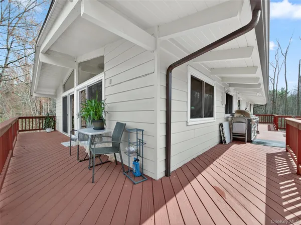 a view of a patio with table and chairs with wooden floor and floor to ceiling window