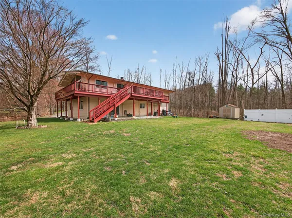 a front view of house with yard and trees in the background