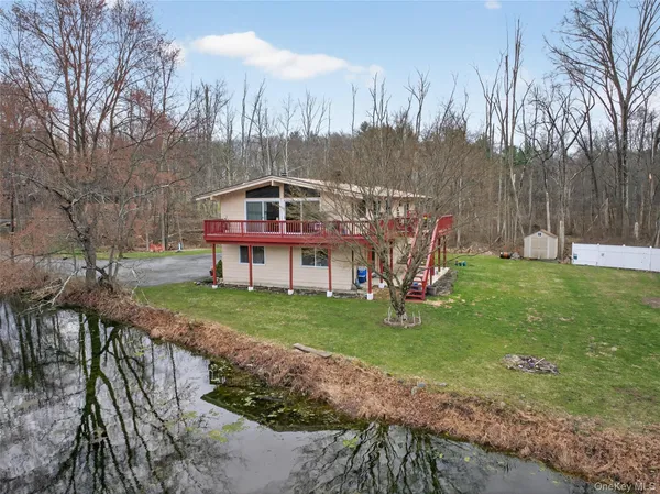 a view of a house with backyard and trees