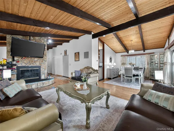 a living room with furniture a fireplace a flat screen tv and a large window