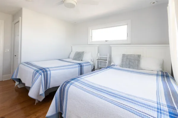 a bedroom with two beds and wooden floor