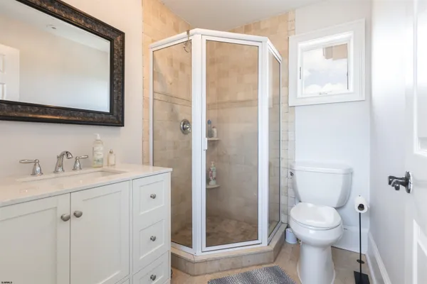 a bathroom with a granite countertop sink toilet and shower
