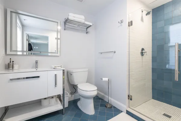 a bathroom with a toilet sink a mirror and shower