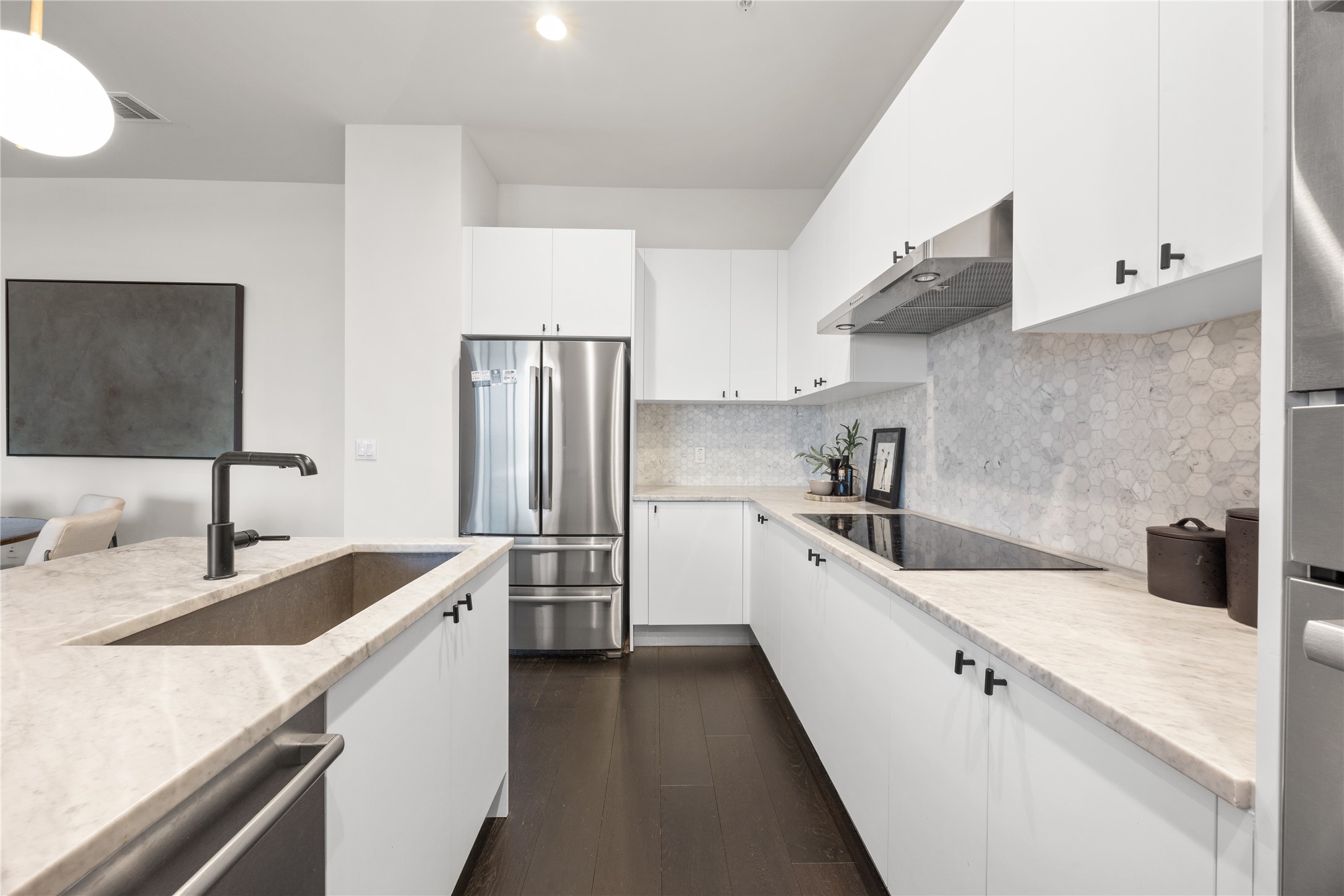 800 Embassy Drive, Unit 602 Austin, TX 78702 - Photo 12 of 37 Contemporary kitchen featuring white cabinetry, light-toned countertops, a stainless steel refrigerator, and a hexagonal tile backsplash