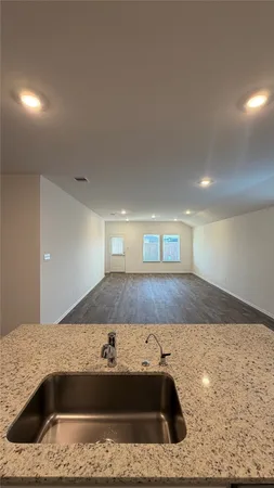 a view of a kitchen island a sink a counter top space and cabinets