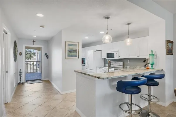 a kitchen with stainless steel appliances granite countertop a sink and a refrigerator