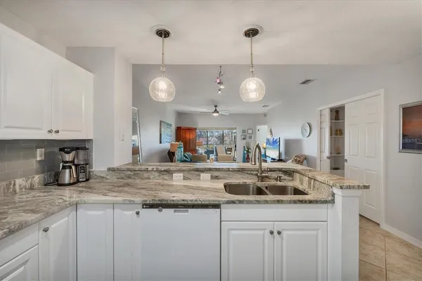 a kitchen with kitchen island granite countertop a sink a counter space and cabinets