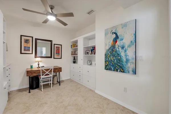 a view of a workspace with furniture and ceiling fan