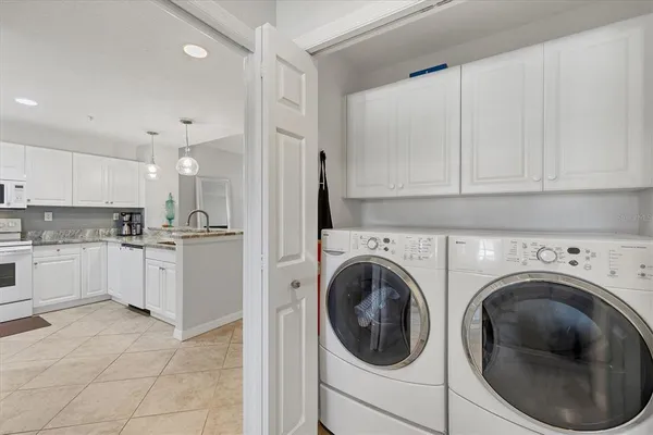 a kitchen with cabinets and washer dryer