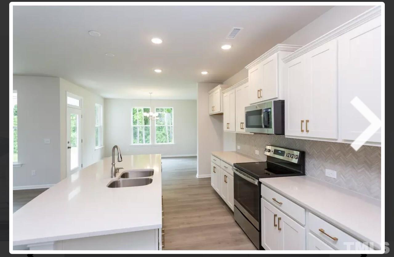 234 Hopper Circle Clayton, NC 27520 - Photo 11 of 22 a kitchen with stainless steel appliances a microwave a sink a stove and cabinets