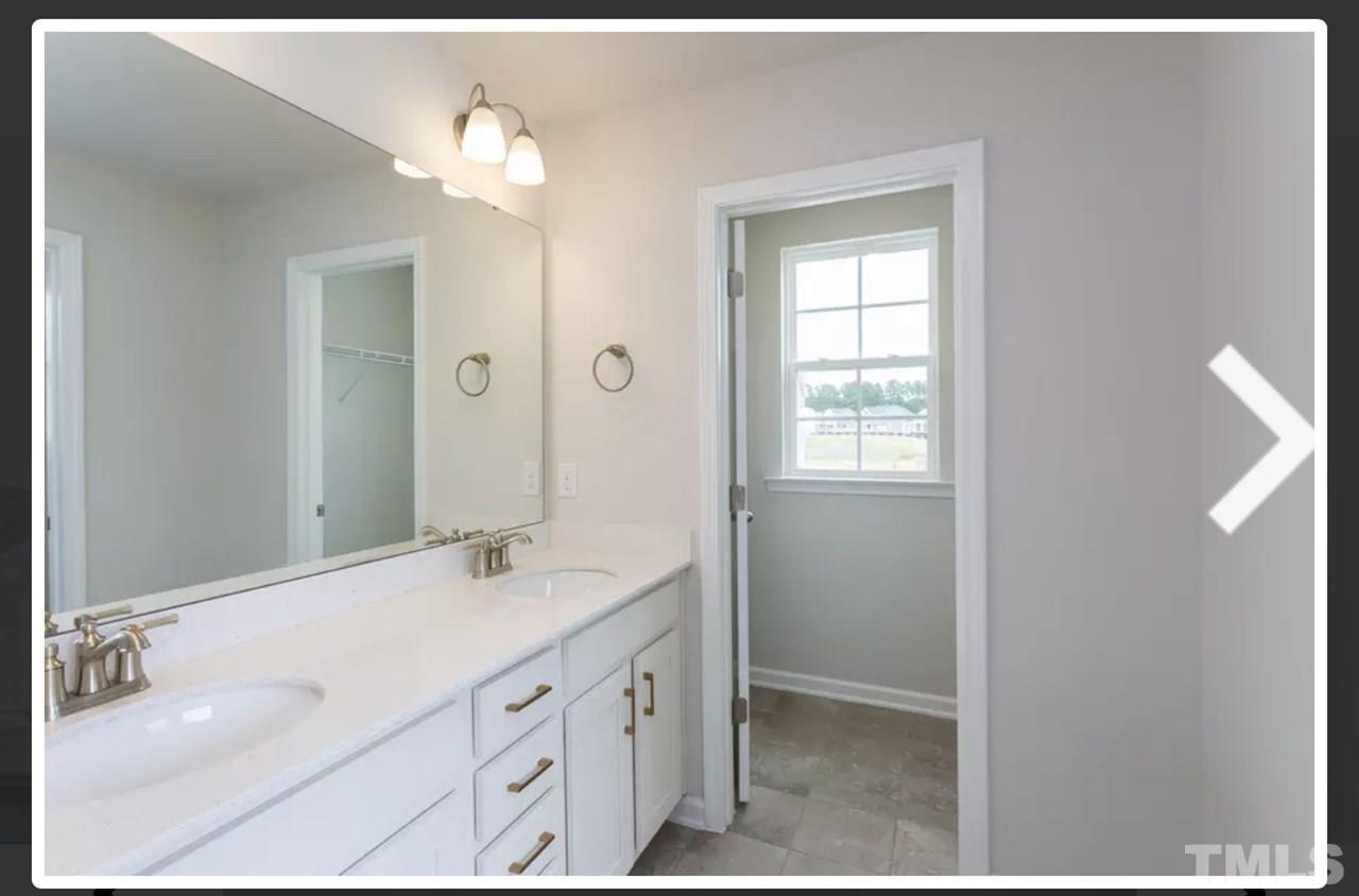 234 Hopper Circle Clayton, NC 27520 - Photo 15 of 22 a bathroom with a double vanity sink and a mirror