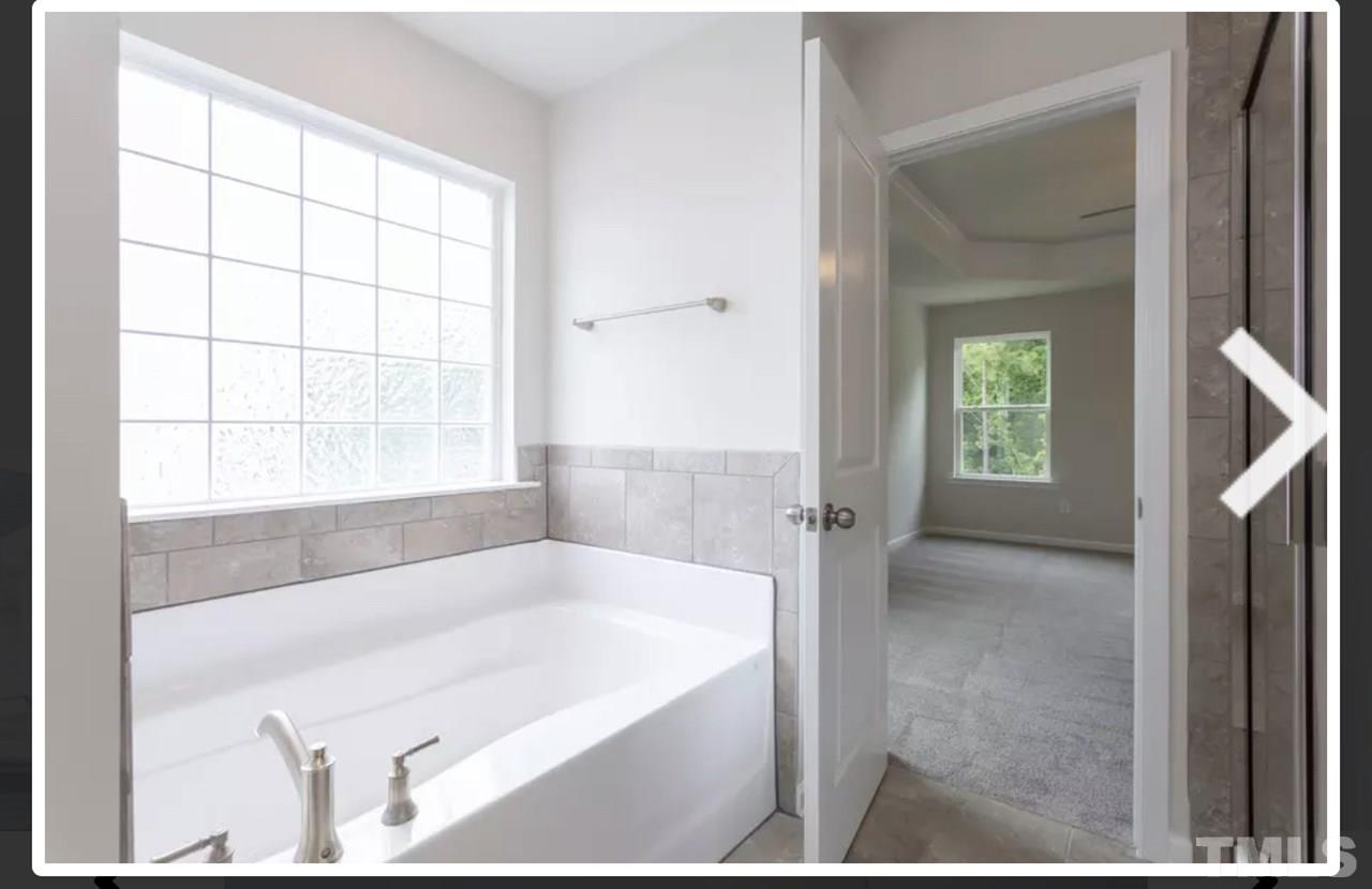 234 Hopper Circle Clayton, NC 27520 - Photo 16 of 22 a bathroom with a bathtub and a shower