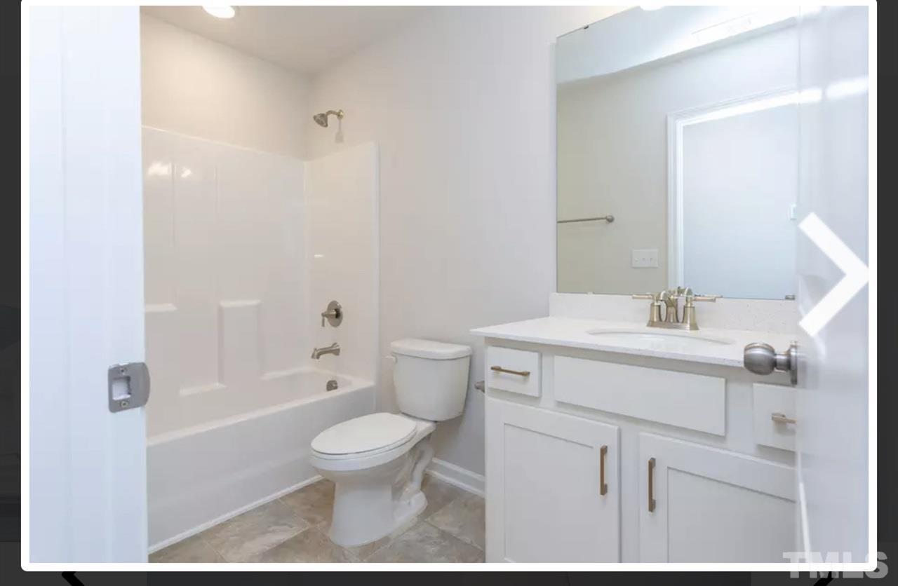 234 Hopper Circle Clayton, NC 27520 - Photo 18 of 22 a bathroom with a sink a toilet and shower