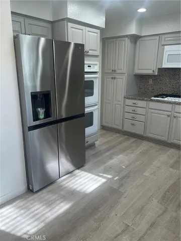 a kitchen with stainless steel appliances granite countertop a refrigerator and a stove