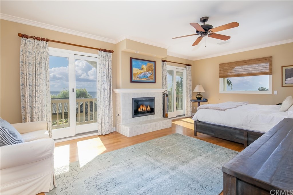 652 Agate Street Laguna Beach, CA 92651 - Photo 14 of 19 a spacious bedroom with a large bed a flat screen tv and a fireplace