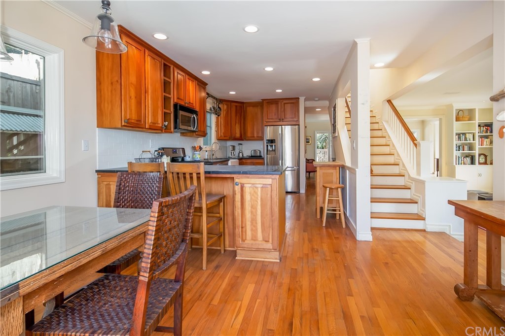 652 Agate Street Laguna Beach, CA 92651 - Photo 9 of 19 a kitchen with stainless steel appliances granite countertop wooden floor a stove a sink and a microwave
