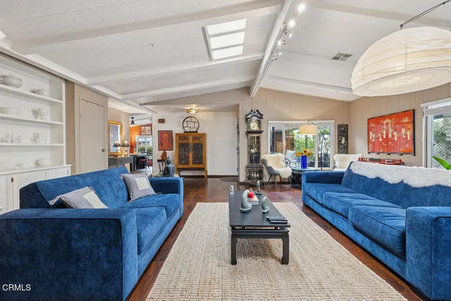a living room with furniture a flat screen tv and a large window