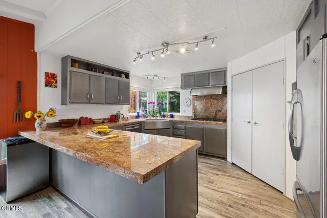 a kitchen with lots of counter top space sink and wooden floor