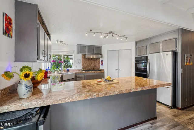 a kitchen with stainless steel appliances granite countertop a refrigerator and a sink