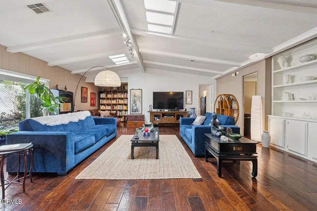 a living room with furniture and wooden floor