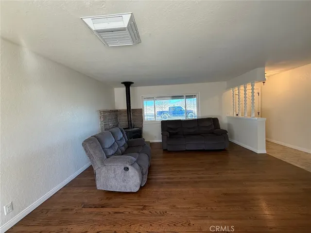 a view of a big room with wooden floor and windows