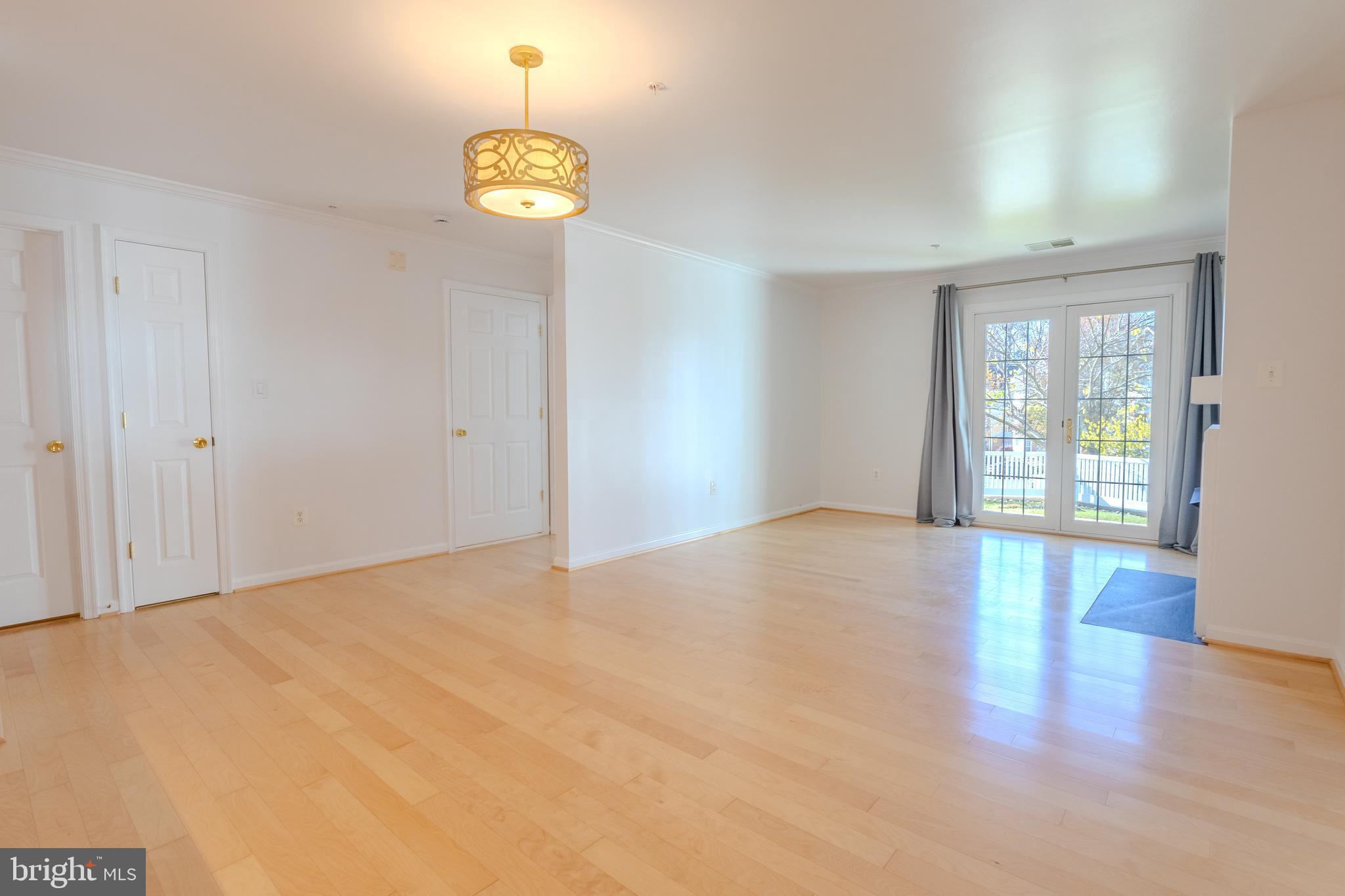 2015 Governor Thomas Bladen Way, Unit 104 Annapolis, MD 21401 - Photo 11 of 32 a view of an empty room with window and wooden floor
