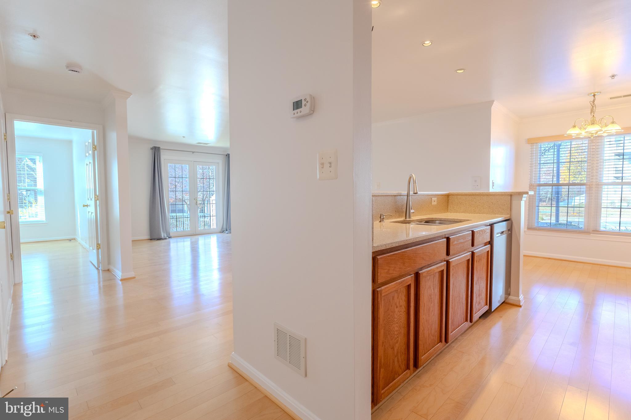 2015 Governor Thomas Bladen Way, Unit 104 Annapolis, MD 21401 - Photo 5 of 32 a hallway with stainless steel appliances granite countertop a stove and a wooden floors