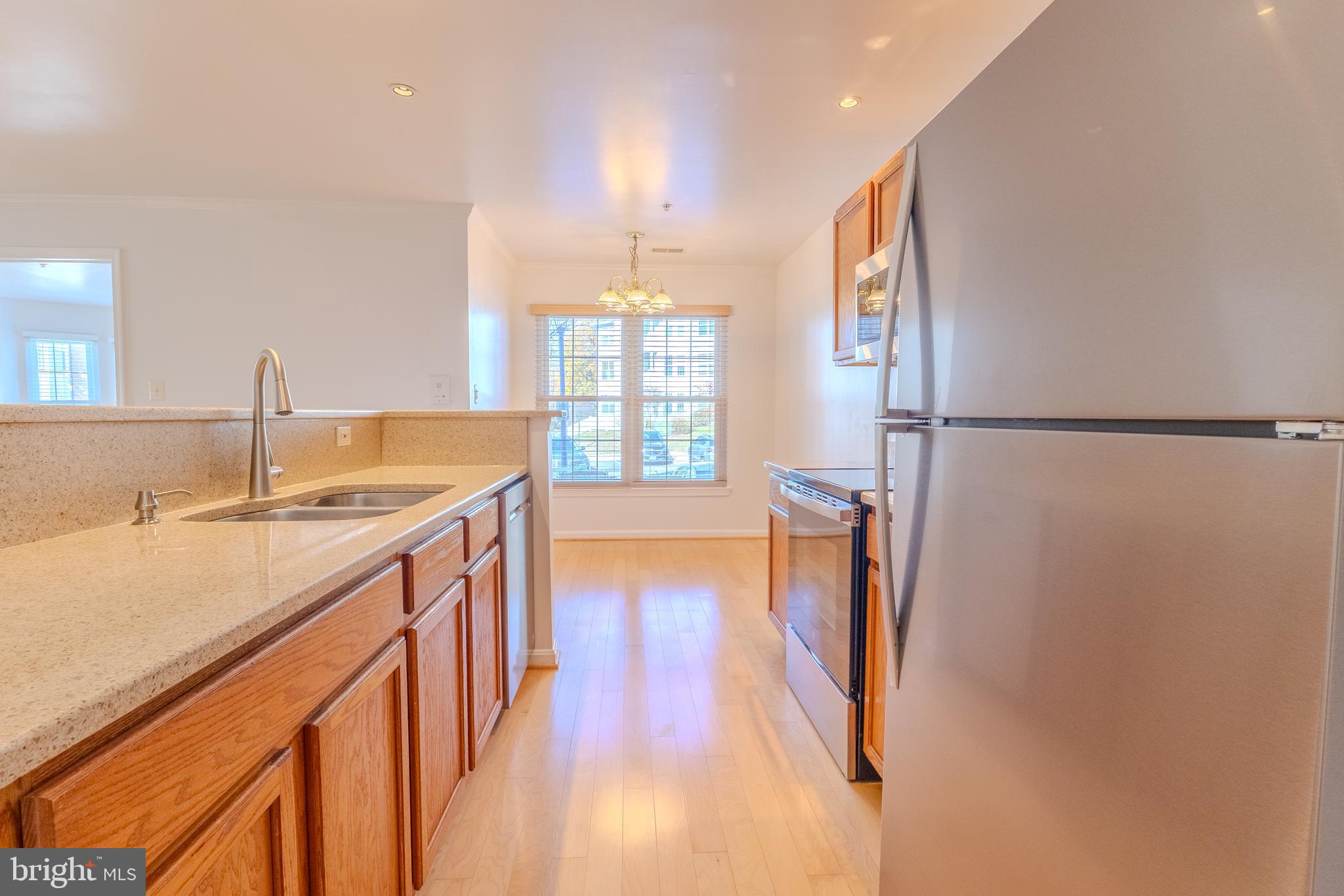 2015 Governor Thomas Bladen Way, Unit 104 Annapolis, MD 21401 - Photo 6 of 32 a kitchen with stainless steel appliances granite countertop a refrigerator and a sink