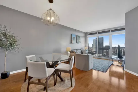 a dining room with furniture a chandelier and wooden floor