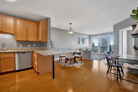 a large white kitchen with lots of counter top space and stainless steel appliances