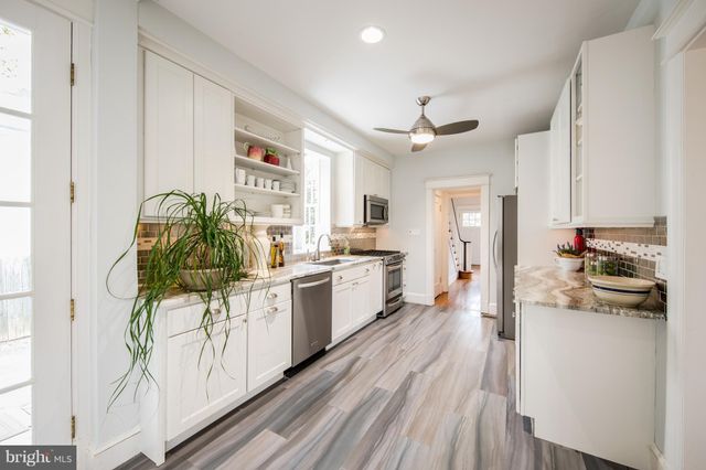a kitchen with a sink a refrigerator and cabinets