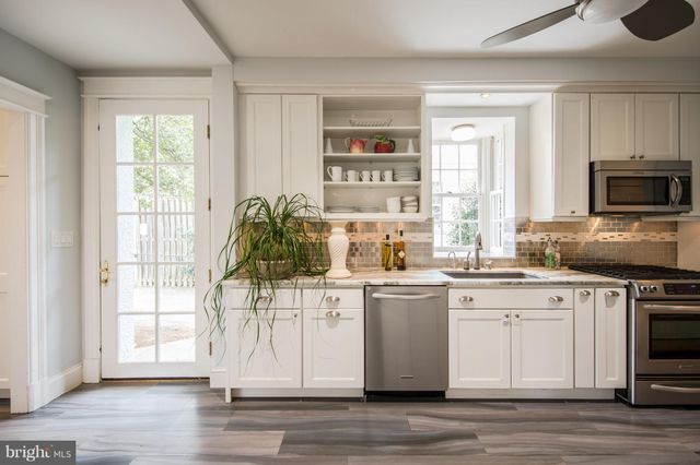 a kitchen with a stove a sink and a window