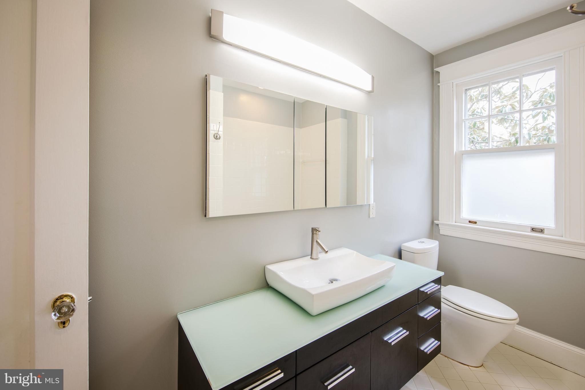 3430 34th Place Northwest Washington, DC 20016 - Photo 22 of 29 a bathroom with a sink toilet a mirror and window