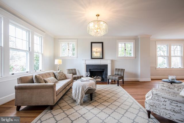 a living room with furniture chandelier and a fireplace