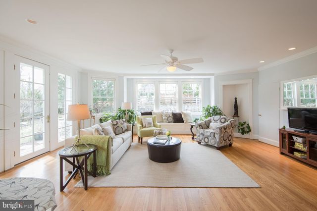 a living room with furniture a flat screen tv and a large window