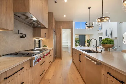 a kitchen with stainless steel appliances granite countertop a sink a stove and a wooden floors