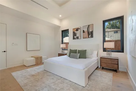 a bedroom with a large bed and paintings on the wall