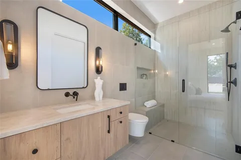 a bathroom with a double vanity sink toilet mirror and shower
