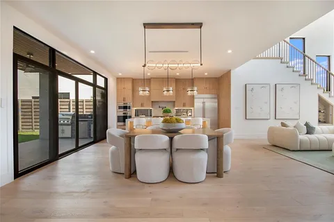 a large white kitchen with a large window and stainless steel appliances